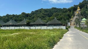 A row of green-roofed buildings with a road leading to a hill with a golden statue. - Luxury Private Pool Villa- Ao Nang Krabi  (Tambon Ao Nang)