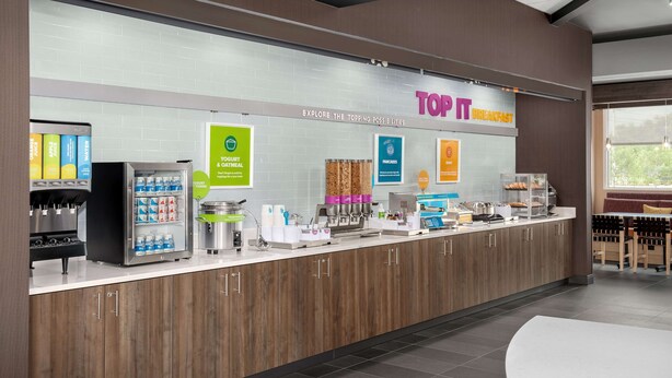 A breakfast counter with a variety of food and drink options, including yogurt, oatmeal, and pancakes. - Tru by Hilton Jacksonville Airport I-95 (Jacksonville)