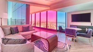 Una sala de estar moderna con un sofá grande, una mesa de centro y una zona de comedor con sillas.