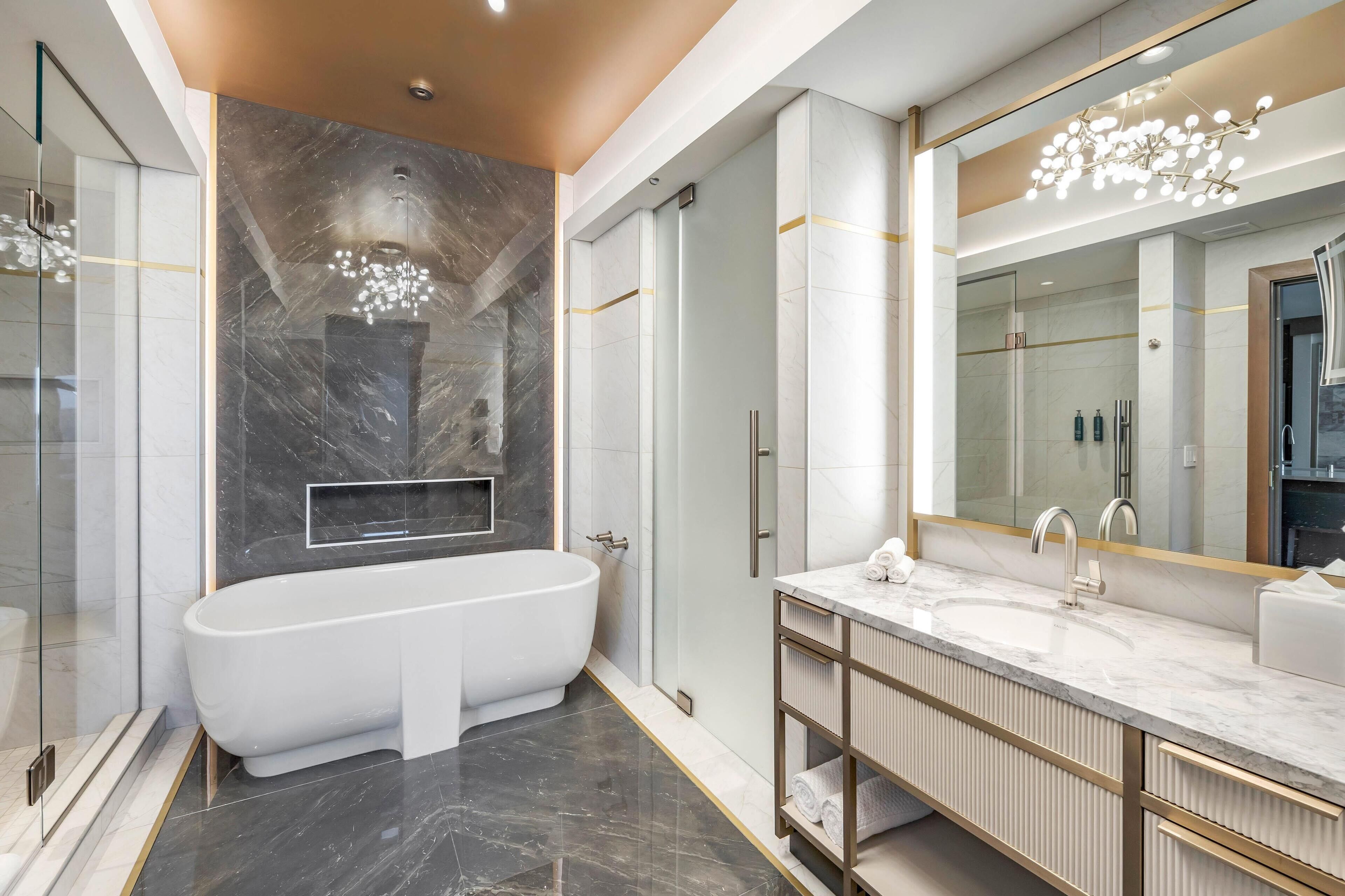 A modern bathroom with a freestanding bathtub, a large mirror, and a vanity with a sink.