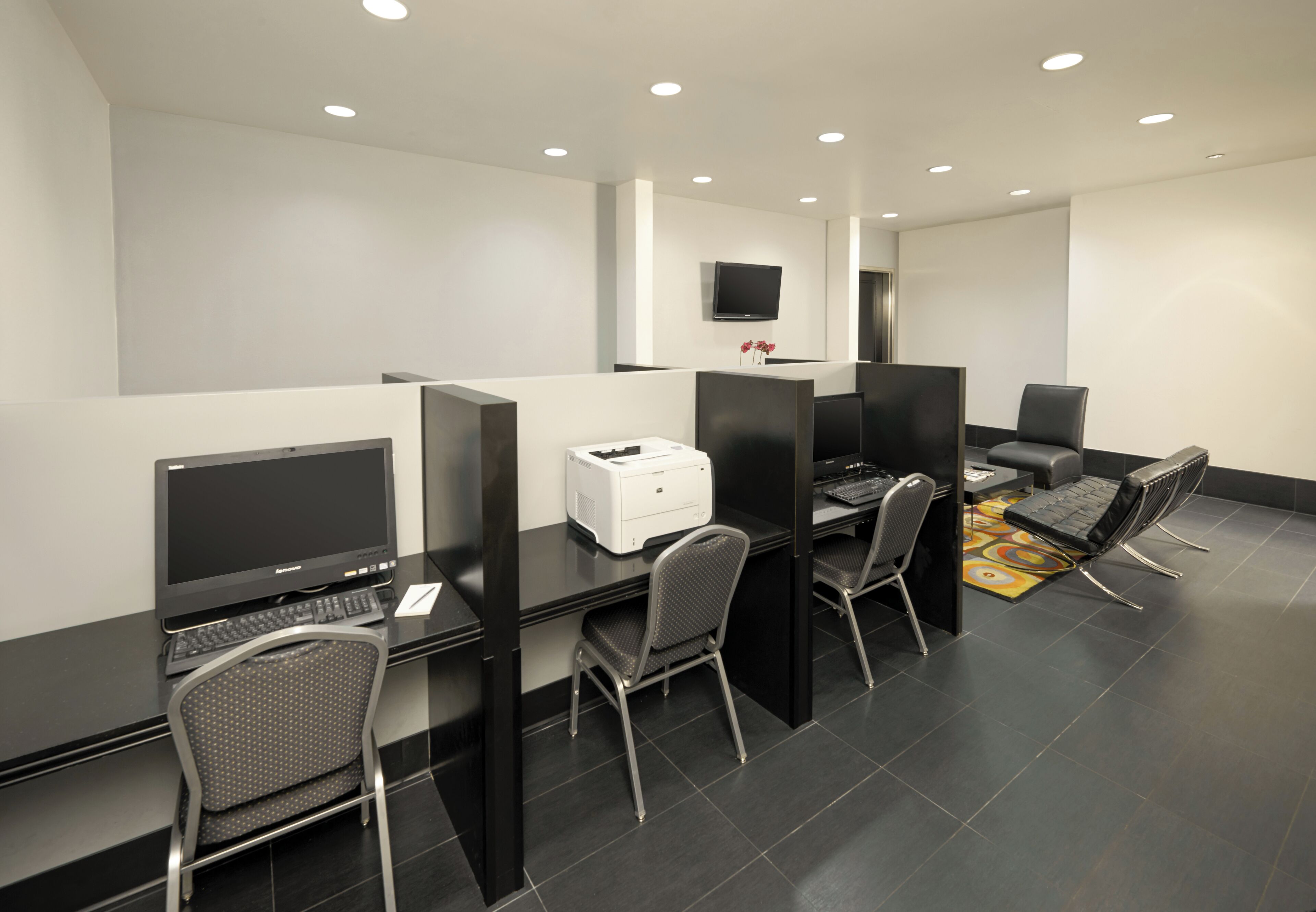 Un espace de bureau moderne, avec des cloisons, des ordinateurs et des chaises.