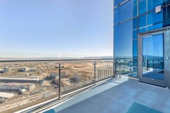 A modern hotel lobby with a large reception desk, a digital display, and a unique ceiling design. at Hilton Club Elara Las Vegas
