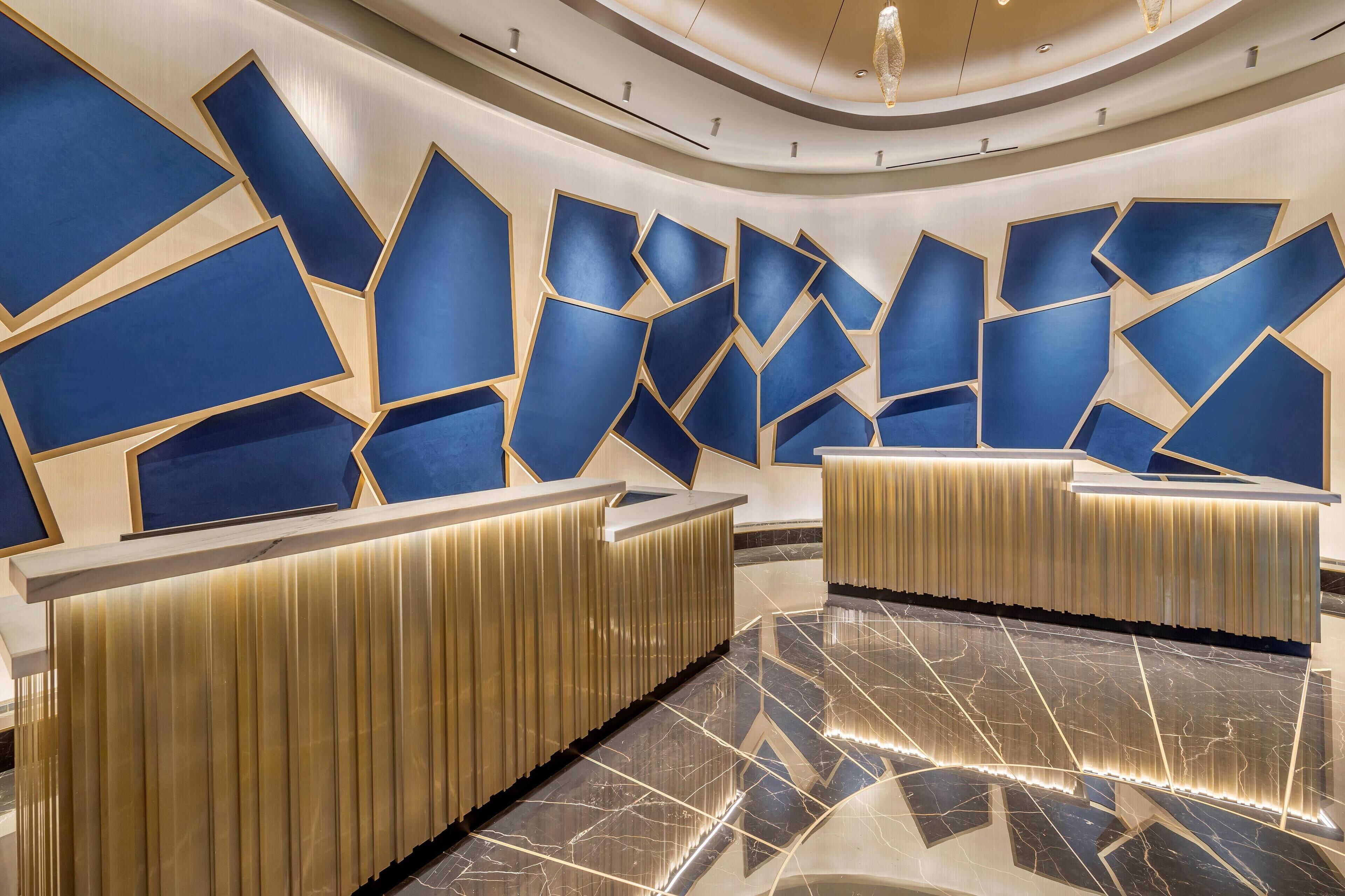 Uma área de recepção moderna com designs geométricos nas paredes e piso de mármore polido.
