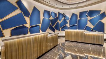 Uma área de recepção moderna com designs geométricos nas paredes e piso de mármore polido.