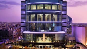 Experience the sleek, curved design of this Hilton hotel, featuring a central atrium and expansive city views.