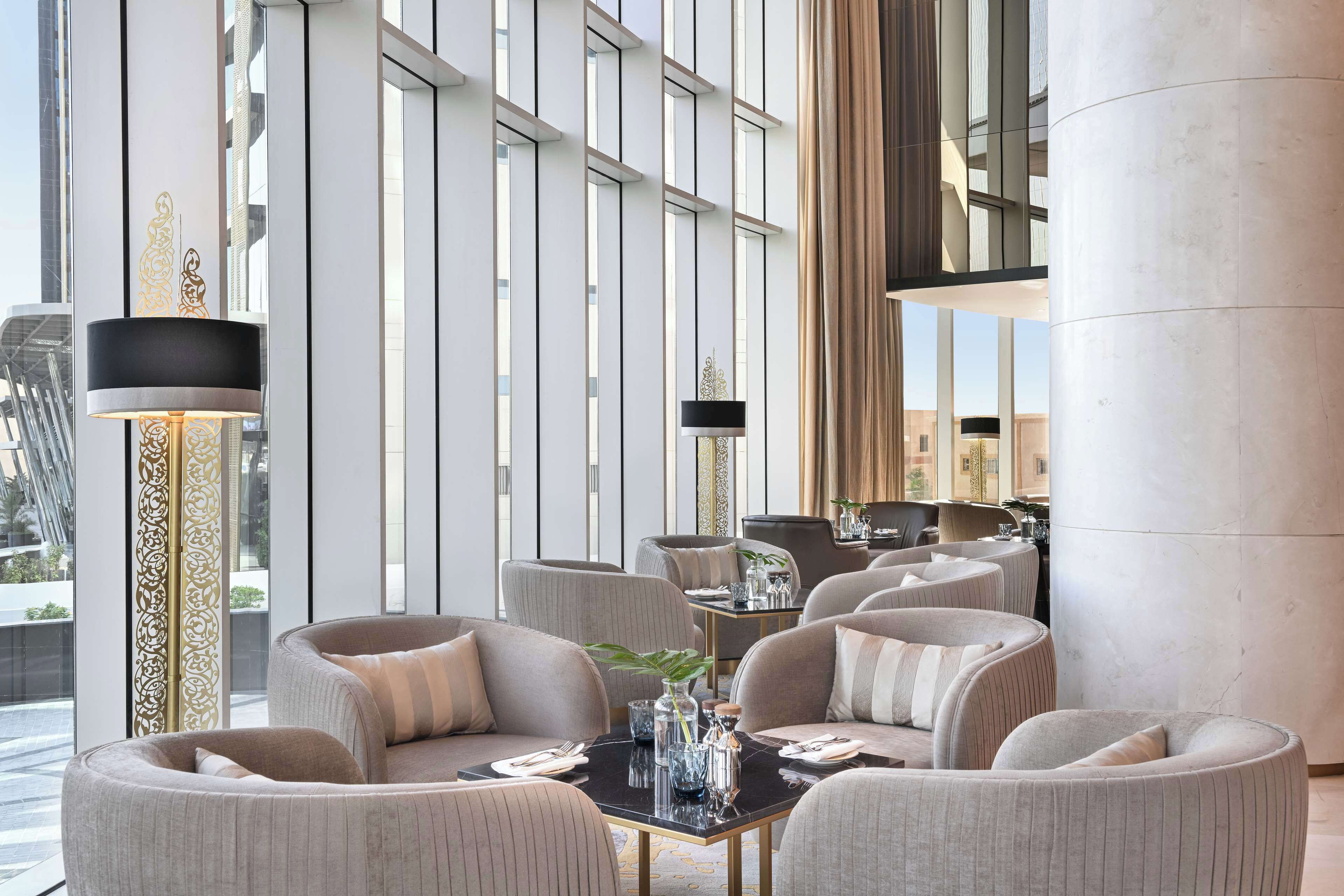 Un intérieur moderne avec un espace salon, de grandes fenêtres et une colonne décorative.