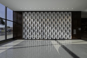 Um interior moderno com parede estampada, entrada de vidro e chão liso.
