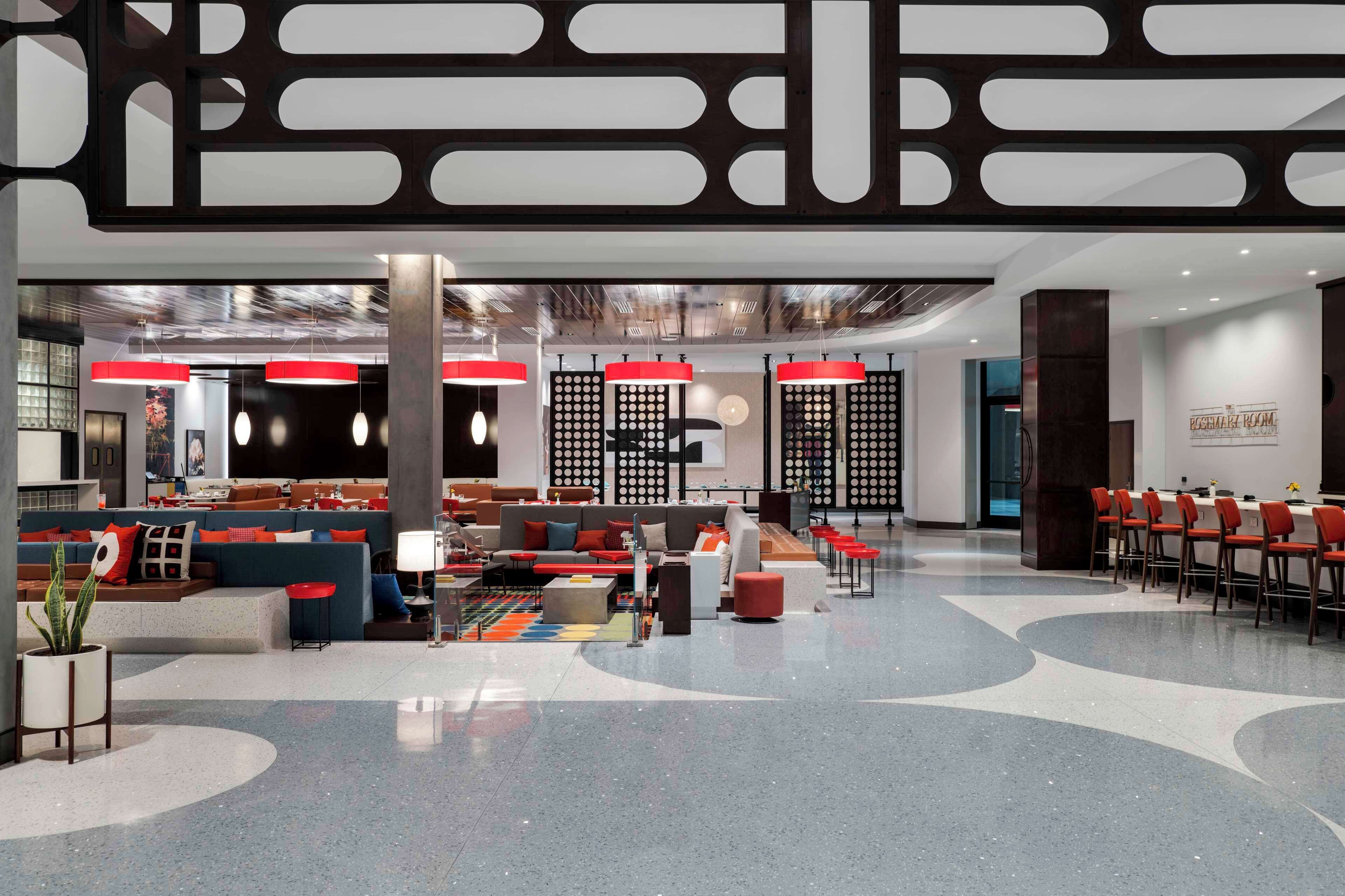 Un vestíbul modern amb zona de seients, taulell de recepció i menjador.