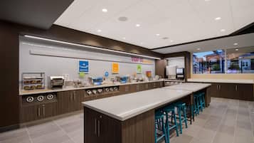 A modern breakfast bar with a variety of food options and seating.