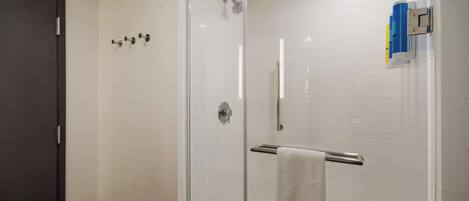 Une salle de bain moderne avec une douche à parois de verre, un porte-serviettes et une porte.