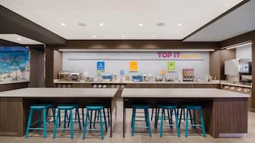 A modern breakfast area with a central island, bar stools, and a variety of breakfast options displayed.