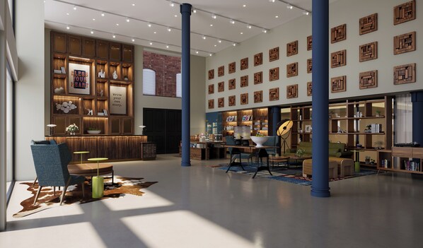 Un hall d’entrée spacieux comprenant un comptoir d’accueil, un espace salon et un mur orné d’œuvres d’art géométriques en bois.