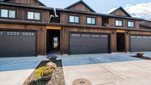 A modern two-story house with a garage and a driveway. - Basecamp Stays: Stylish Home - Hot Tub, AC, Garage (Driggs)