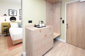 A hotel room with a bed, a desk with a kettle, a wardrobe, and a door. - Hampton By Hilton London Old Street (London)