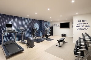 A gym with treadmills, elliptical machines, and weight benches. - Hampton By Hilton London Old Street (London)