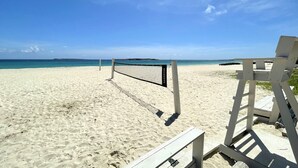 Una red de voleibol de playa en una arena con cielo despejado.