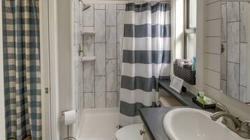 A bathroom with a bathtub, toilet, and sink.