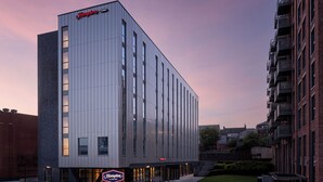 A modern hotel building with a prominent "Hampton by Hilton" sign, featuring a clean, vertical facade and a well-lit entrance. - Hampton By Hilton Rochdale (Rochdale)