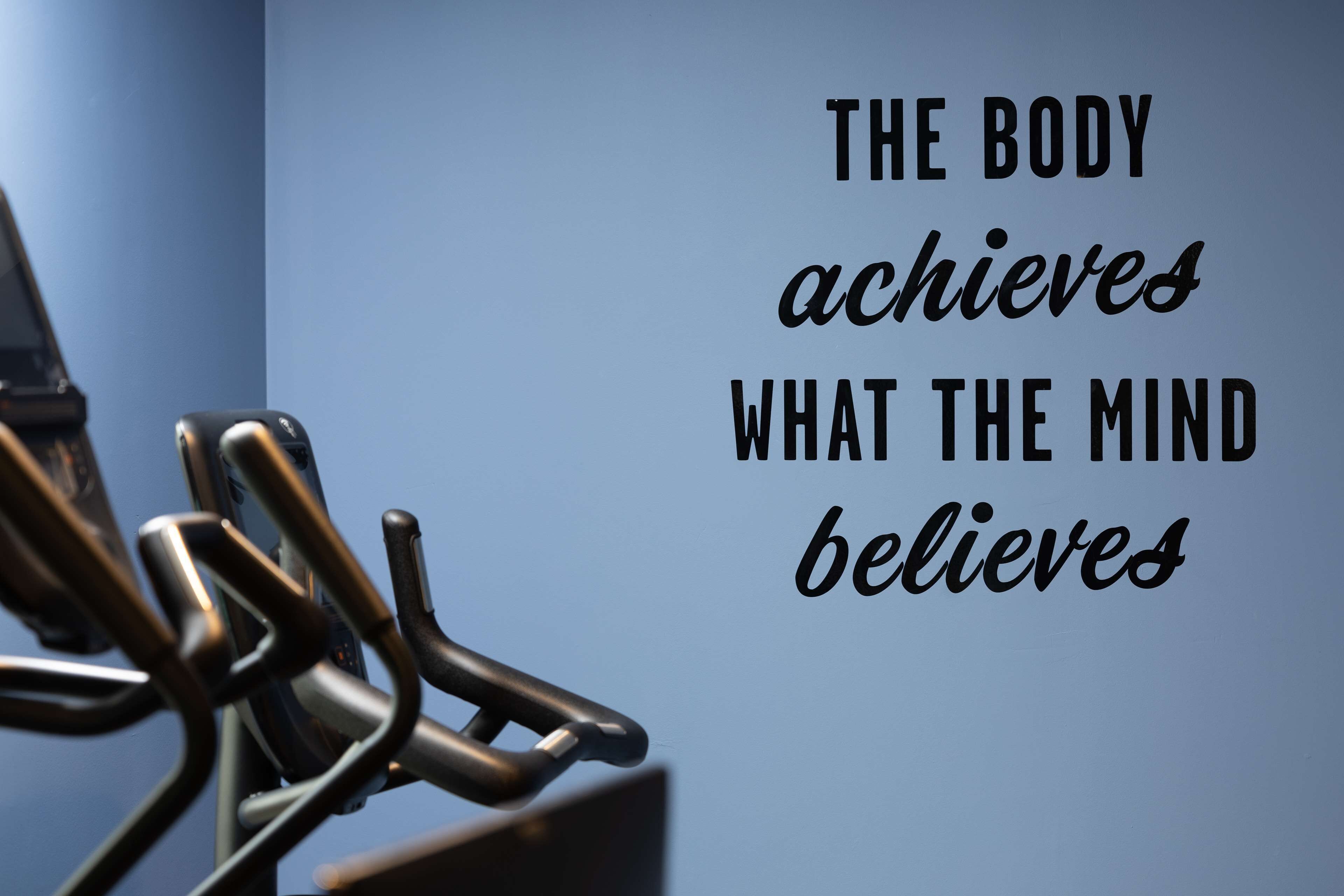 A motivational quote on a wall with a metal structure in the foreground.