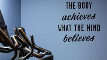 A motivational quote on a wall with a metal structure in the foreground.