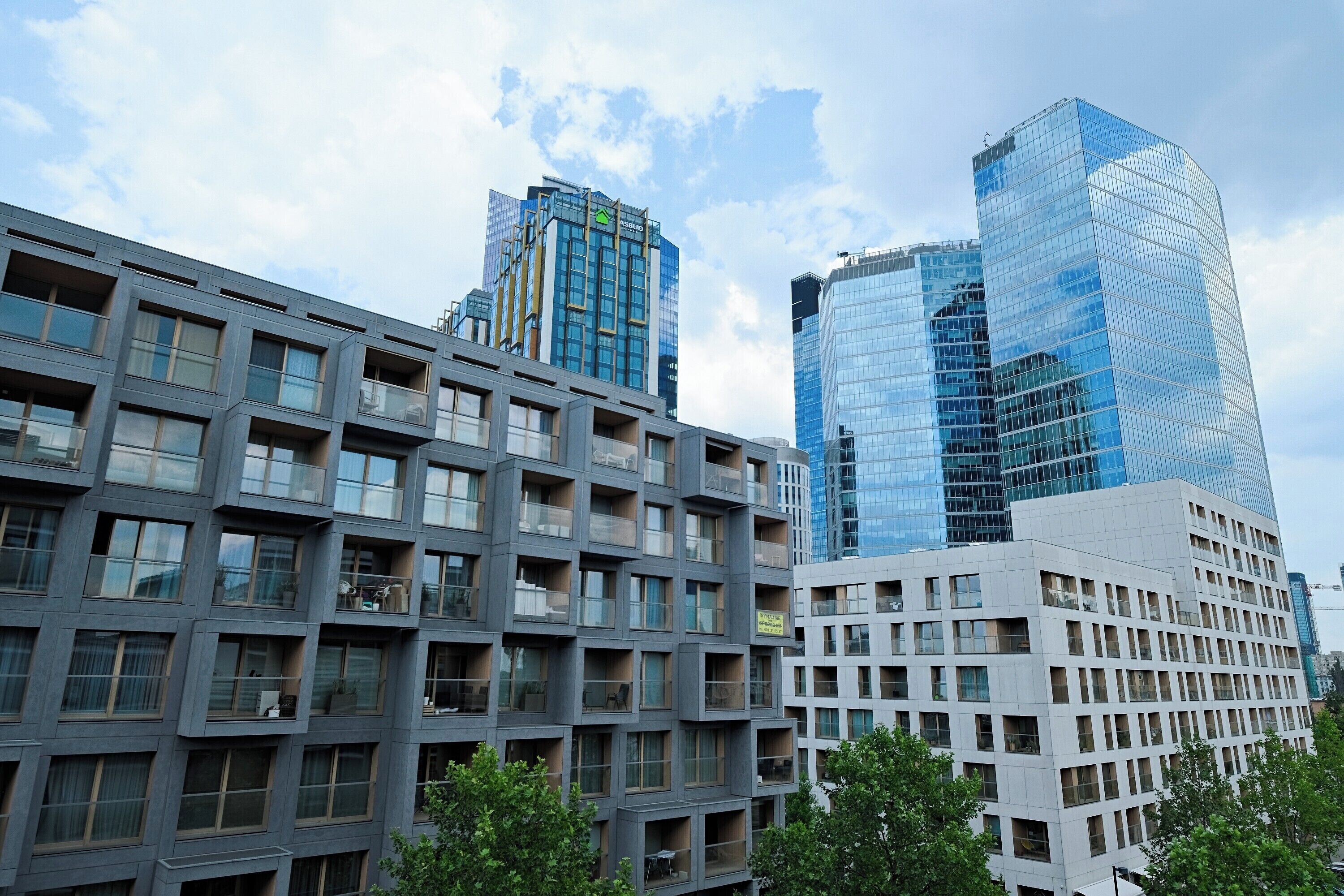 A modern building with multiple floors, large windows, and balconies.
