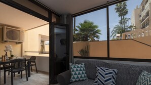 A balcony with a sofa, chairs, and a dining table.