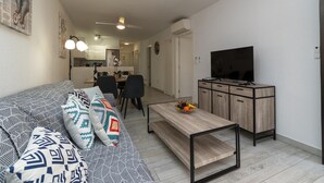A modern living room with a sofa, coffee table, and TV stand.