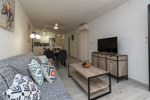 Una sala de estar moderna con un sofá, una mesa de centro y un mueble para televisión.