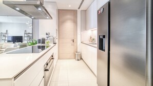 A modern kitchen with stainless steel appliances, a built-in oven, and a large refrigerator. - Picturesque Balcony and Beach Haven at Address JBR (Dubai)