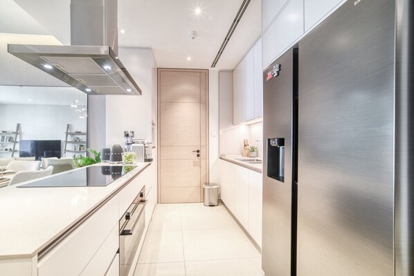 A modern kitchen with stainless steel appliances, a built-in oven, and a sleek countertop.