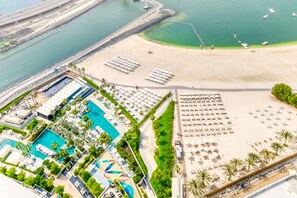 A resort with multiple swimming pools, a beach area with sun loungers, and a marina. - Picturesque Balcony and Beach Haven at Address JBR (Dubai)