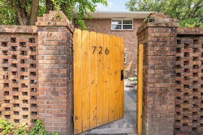 A brick wall with a wooden gate marked with the number 726. - Beach Retreat Near Charleston & Creek (Mount Pleasant)