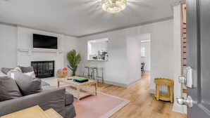 Un salon moderne avec une cheminée, un téléviseur et un coin repas équipé de chaises.