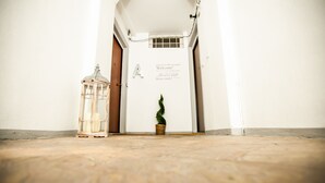 A hallway with a welcome sign, a lantern, and a potted plant. - Lakeside (Como)
