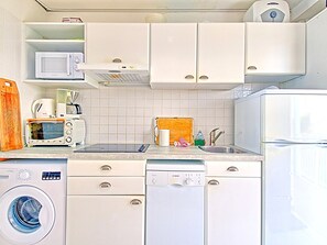 A compact kitchen with a microwave, toaster, coffee maker, sink, and dishwasher. - Spacious Studio with Ocean View and Pool (Saint-Martin)