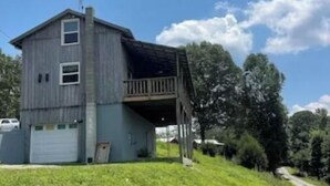 A two-story building with a garage and a covered porch.