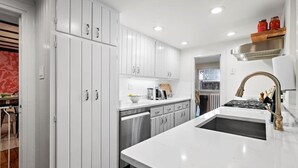 A modern kitchen with white cabinetry, a central island, stainless steel appliances, and a built-in oven. - Historic Home Central Flourtown Hosted By StayRafa (Flourtown)