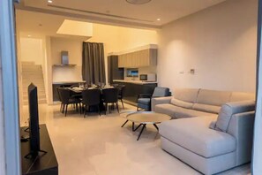 Un salon moderne comprenant un canapé, une table basse et un coin repas avec des chaises et une table.