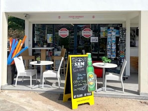 A food market with outdoor seating and a sign advertising SxM beer. - Orchidée Studio at Mont Vernon with views of Orient Bay (Saint-Martin)
