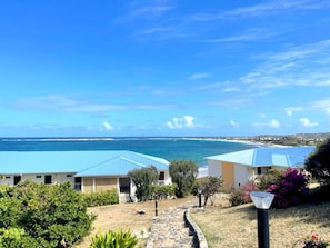 A coastal property with two buildings, a stone pathway, and a view of the ocean.