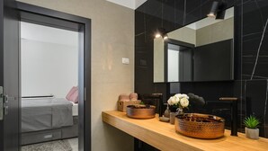 A modern bathroom with a wooden vanity, black marble walls, and a large mirror. - Villa de la Vie with Heated Swimming Pool (Sveti Bartul)