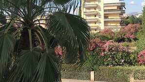 A residential building with balconies, surrounded by lush greenery and flowering bushes. - Appt Standing Face à la Mer (Fréjus)