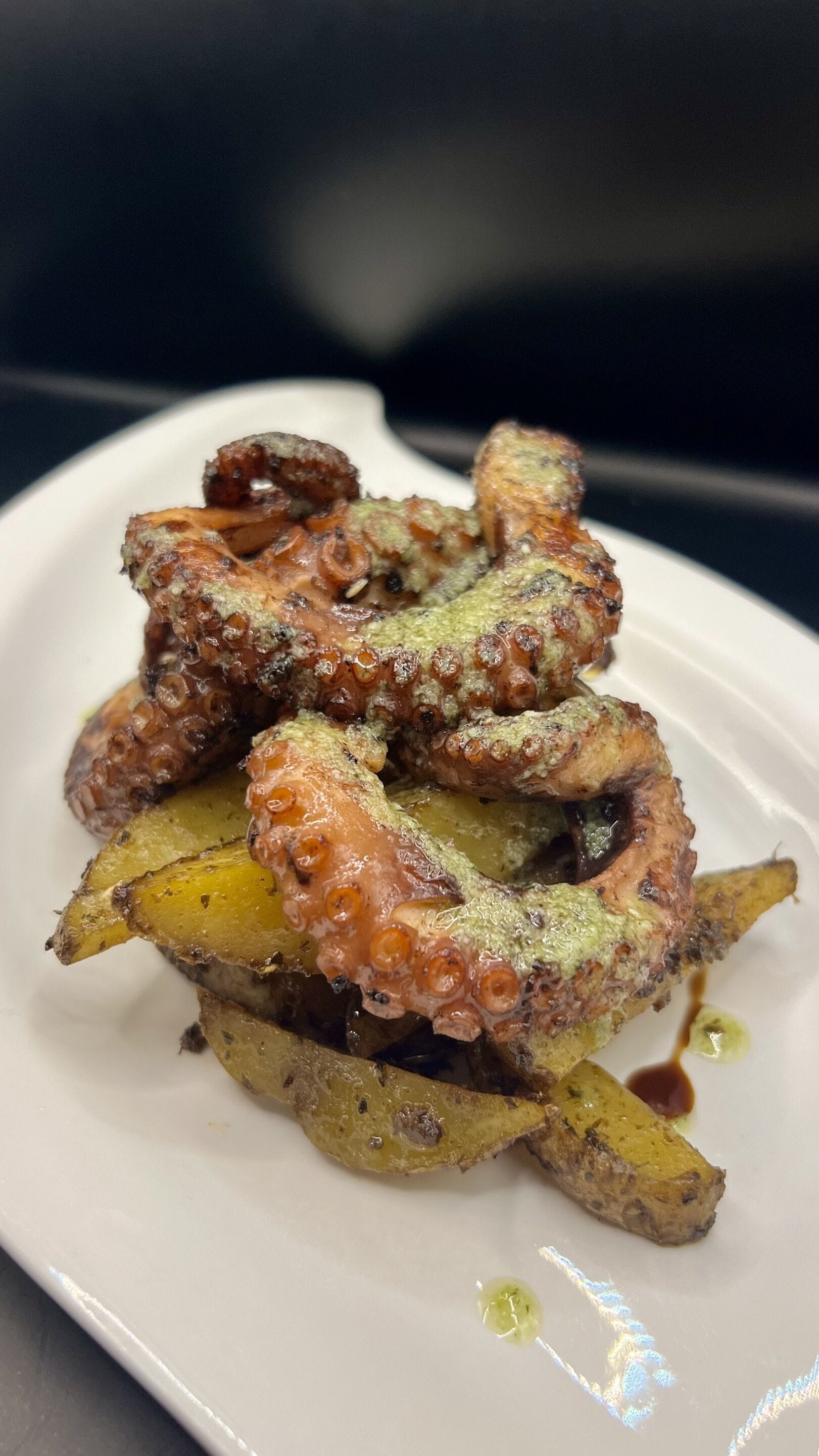 Un plato de tentáculos de pulpo y patatas.