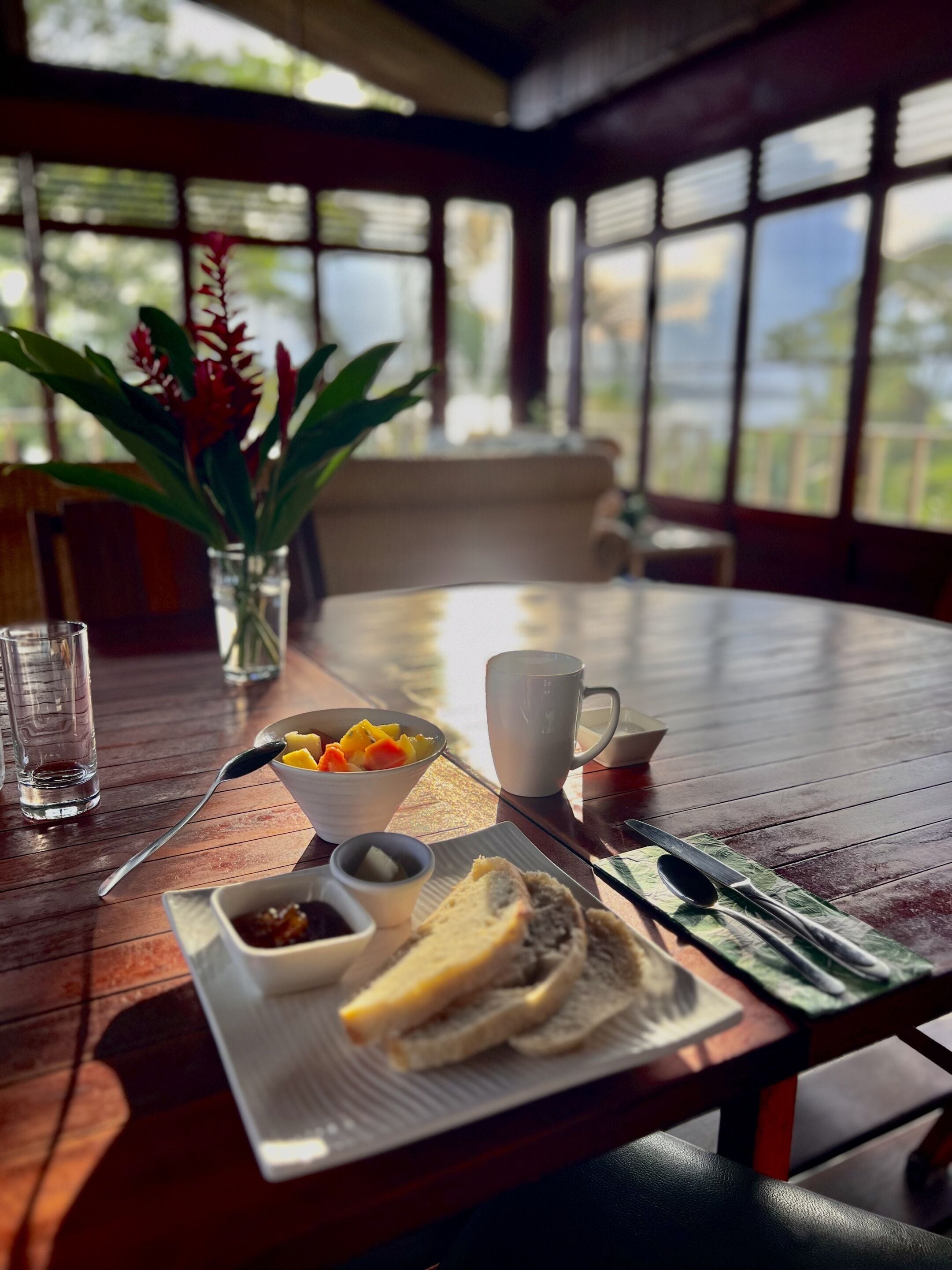A dining table with breakfast items including toast, fruit, and condiments.