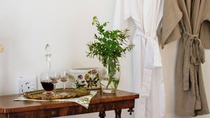 A bathroom with a wooden vanity, a mirror, a towel rack with two robes, and two framed botanical prints on the wall. - Kolonies Tuin (Stellenbosch)