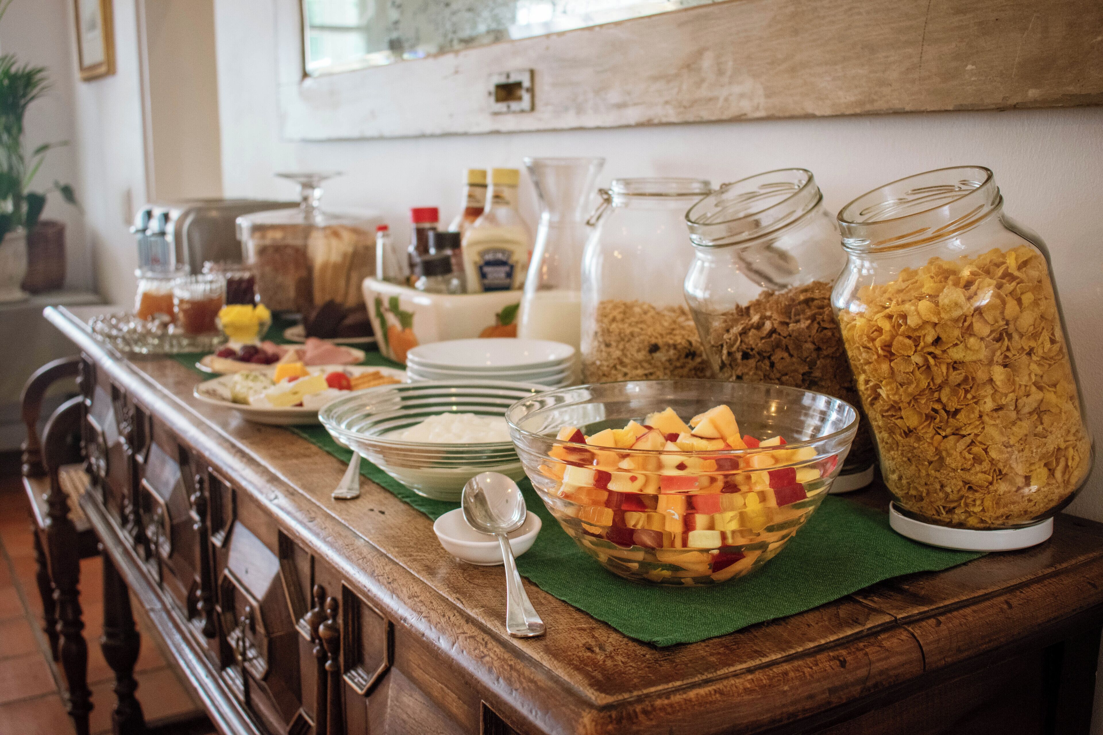 Um buffet de café da manhã com diversos alimentos e acompanhamentos.