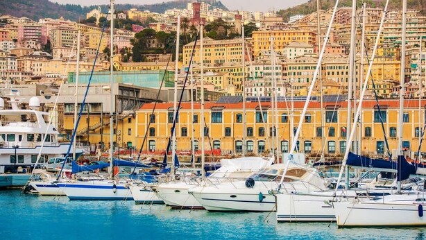 A marina with boats docked in front of colorful buildings.