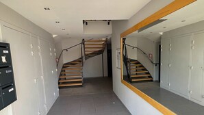 Ein Flur mit Spiegelwand, einer Treppe und Schließfächern.