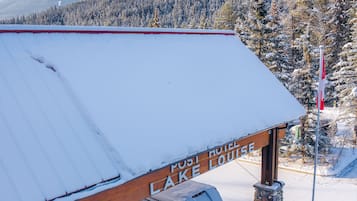 A snow-covered building with a sign reading "PUSI HOTEL LAKE LOUISE."