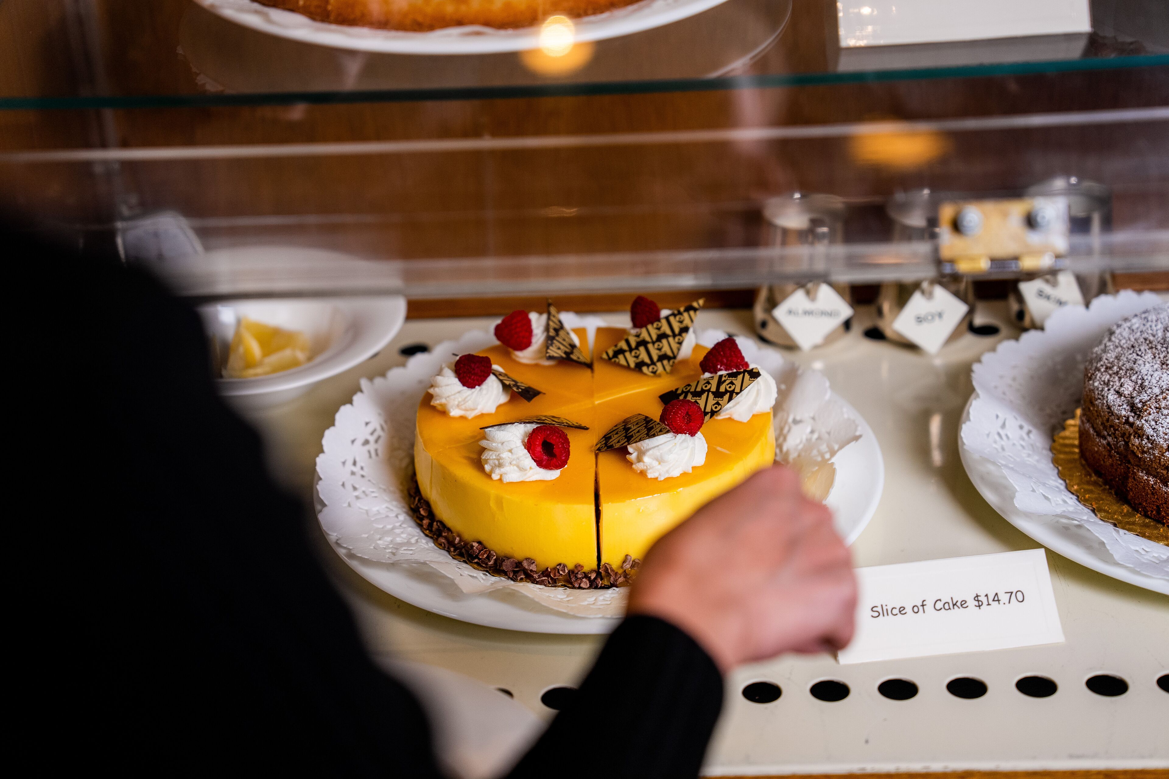 A cake with a price tag in a bakery display case.
